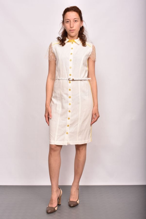 Ленена рокля в бял цвят с ръкав от фина дантела. Моделът е подчертан с жълт кант. Закопчаването е с копчета в златист цвят. Коланът е включен в цената.